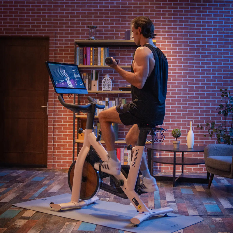 the man is riding freebeat beige spin bike for building muscles